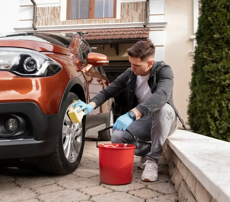 Lavage auto à domicile Ballancourt-sur-Essonne : professionnel intervenant sur un véhicule